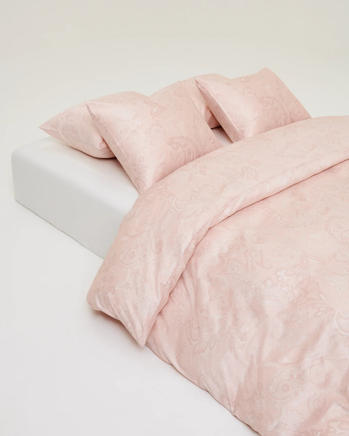 Örngott Paisley Rosa på bäddad säng, närbild